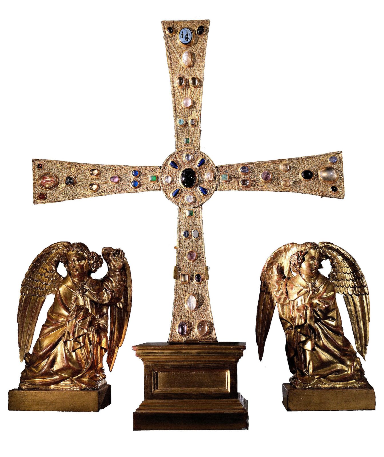 A jewelled gold cross with equal arms flaring at the ends, set with gems and cabochons, flanked by two carved gilt angels on a stand.
