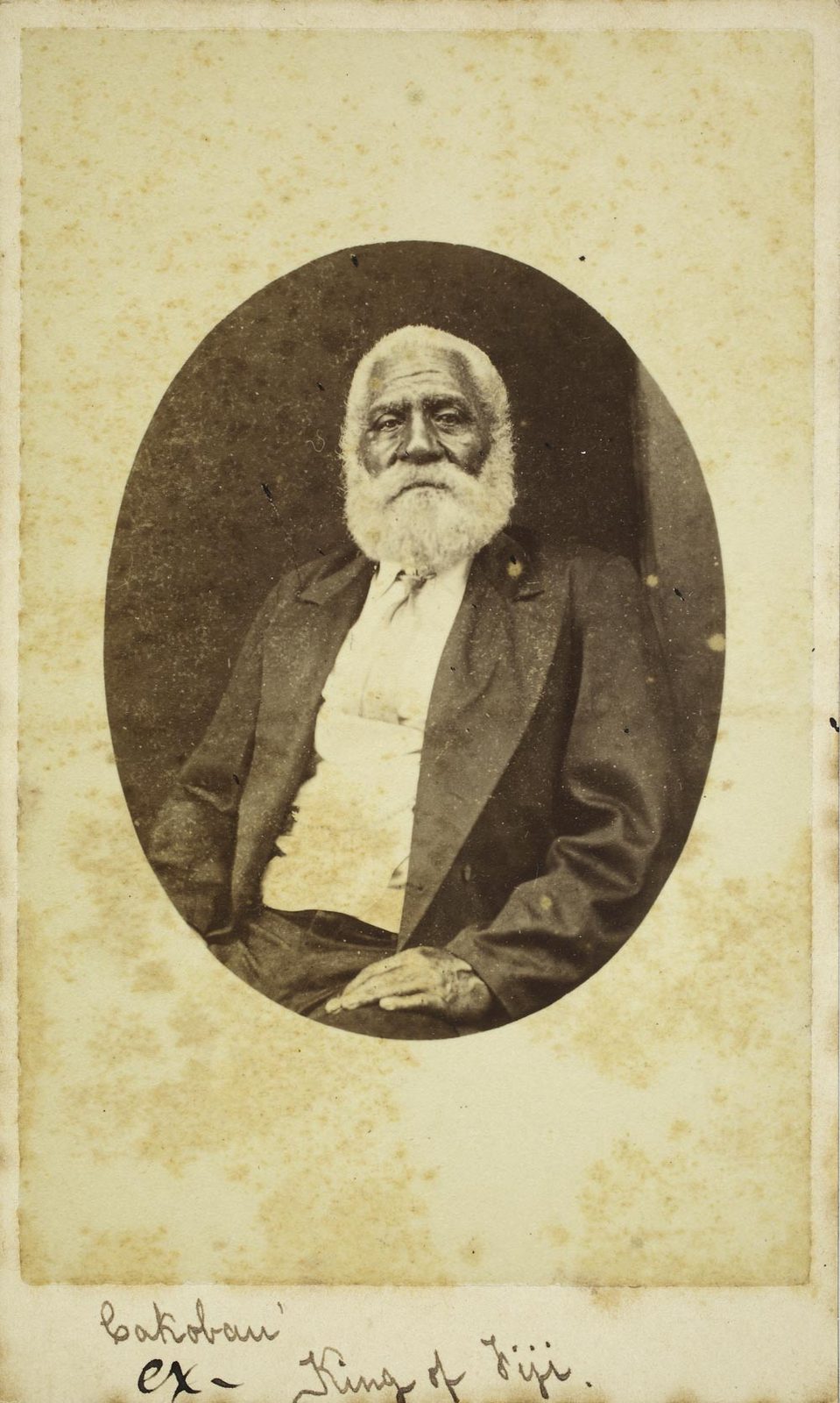 A faded carte-de-visite photograph of an old man with a white beard in a dark suit, in an oval, captioned in ink.