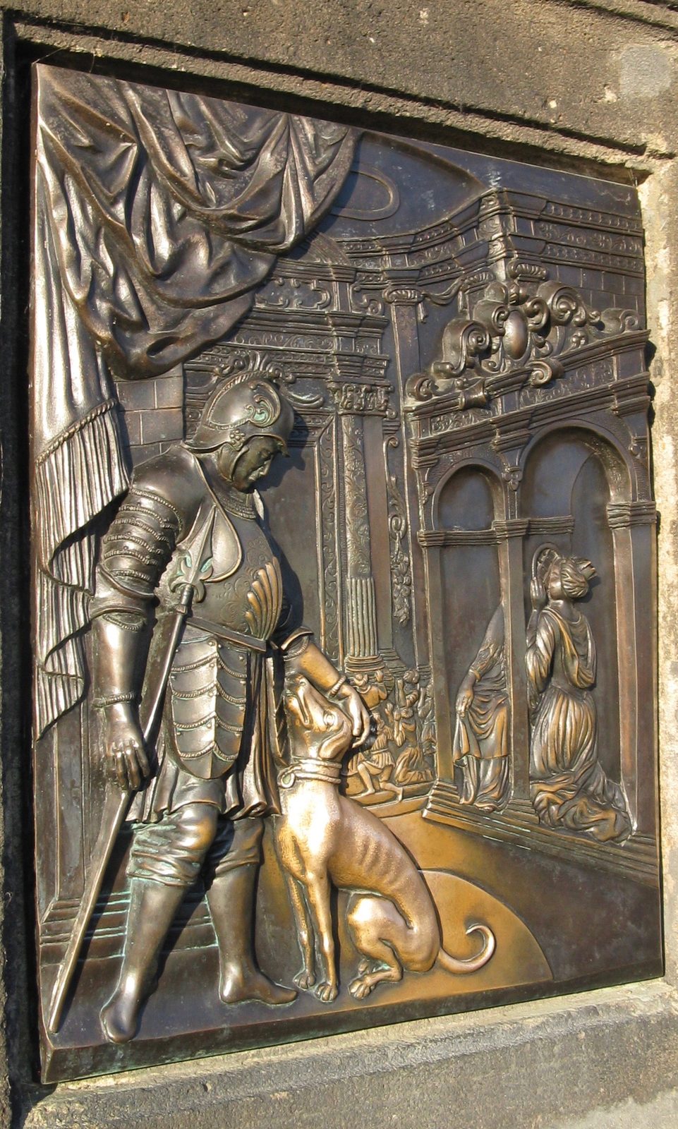 A bronze relief of a man being thrown from a bridge parapet into a river, its surface polished by touch.