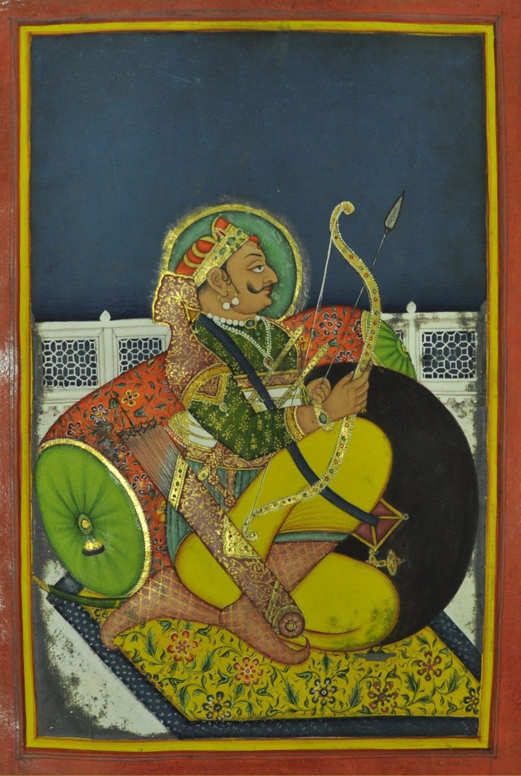 A painting of a crowned king seated on a terrace against a bolster, holding a bow and arrow.