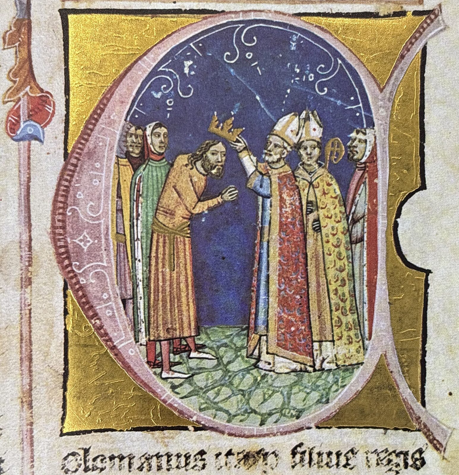 An illuminated initial in which a bishop places a crown on the head of a man in plain dress, clergy and courtiers around them.