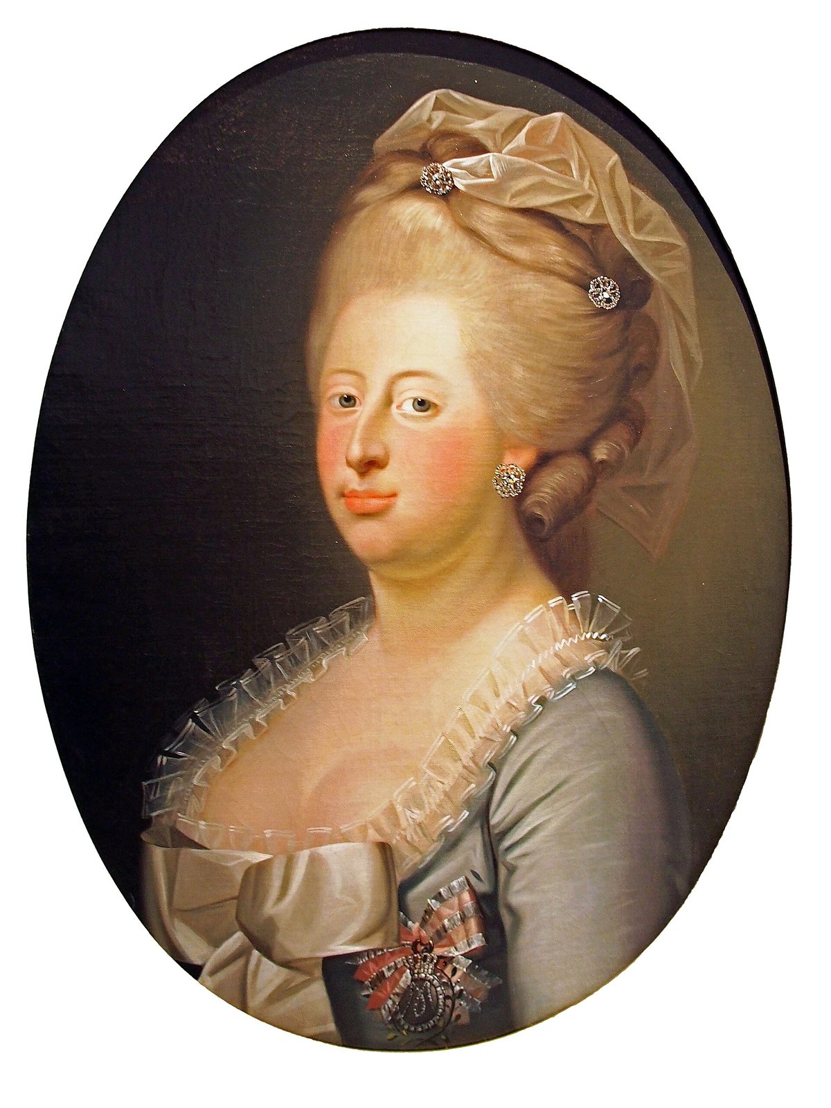 An oval portrait of a young woman with high powdered hair and a grey silk dress.