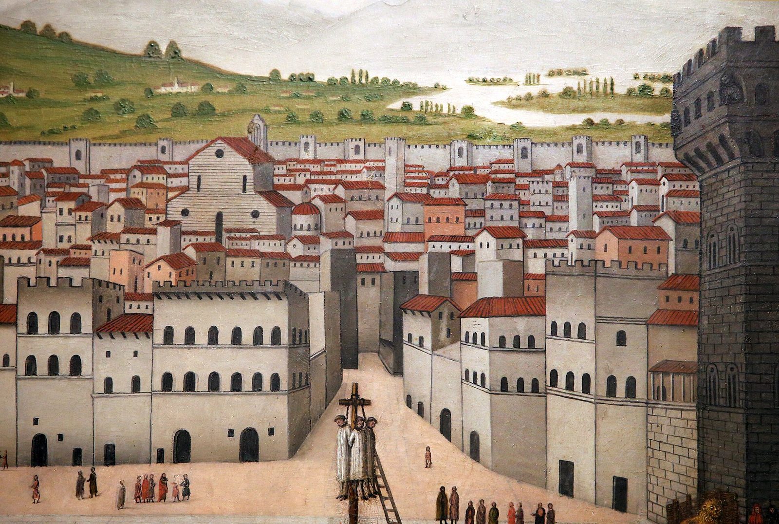A painted panel seen from above: a walled city square with a battlemented palace and tower at the right, a long raised gangway crossing the open ground to a scaffold where three figures hang over a fire, and small groups of onlookers standing well back.