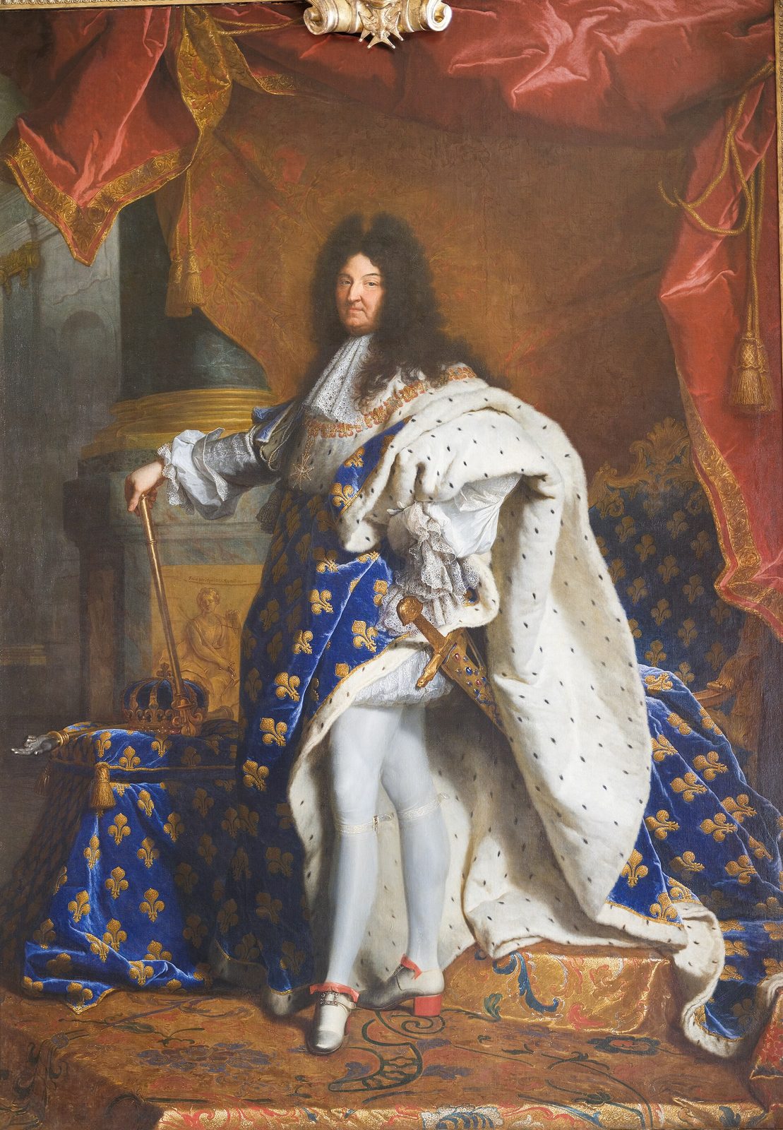 A full-length state portrait of a king in a vast ermine-lined blue mantle worked with gold lilies, wearing a long black wig, one hand on a sceptre and a sword at his hip.
