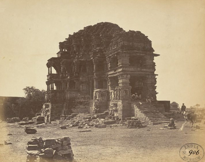 An old photograph of a ruined, heavily carved temple on a stepped platform.