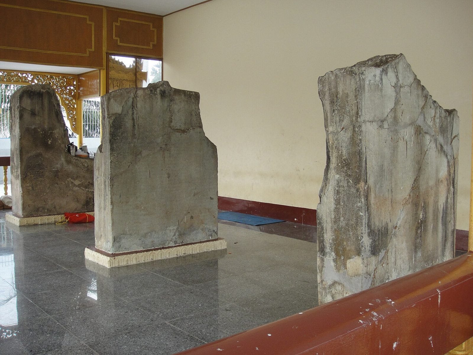 Tall inscribed stone slabs standing in a pavilion.