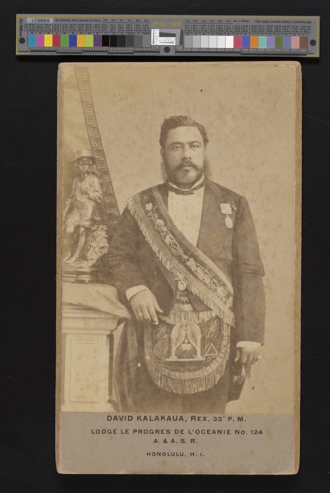 A cabinet photograph of a bearded man in evening dress with a Masonic sash and apron, standing by a column.