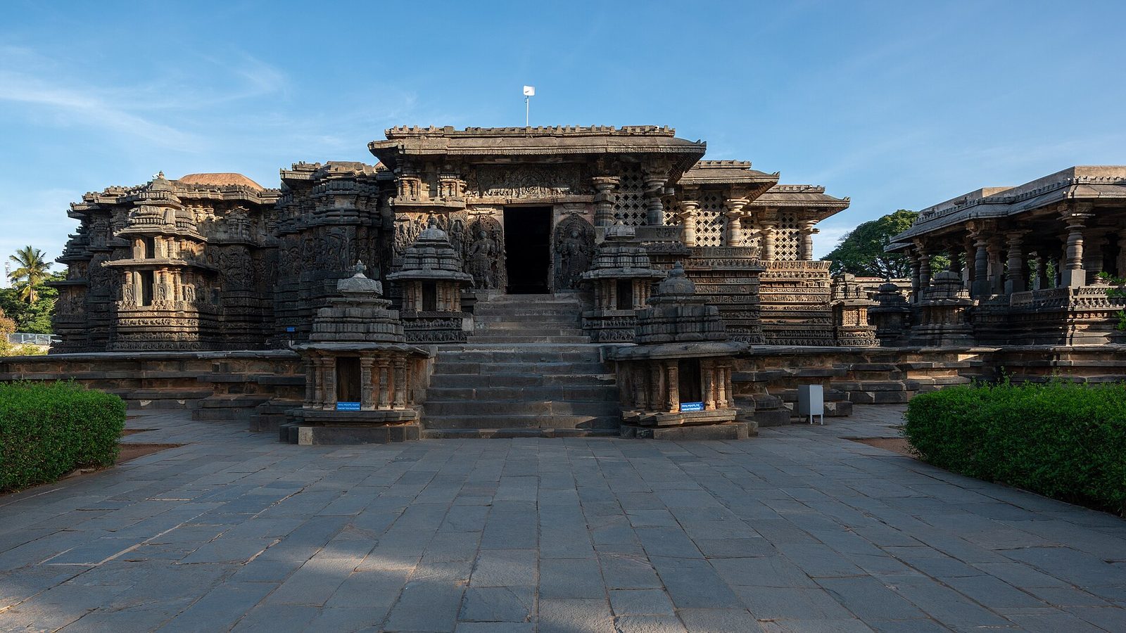 A broad, richly carved stone temple on a platform, with stairs in front.