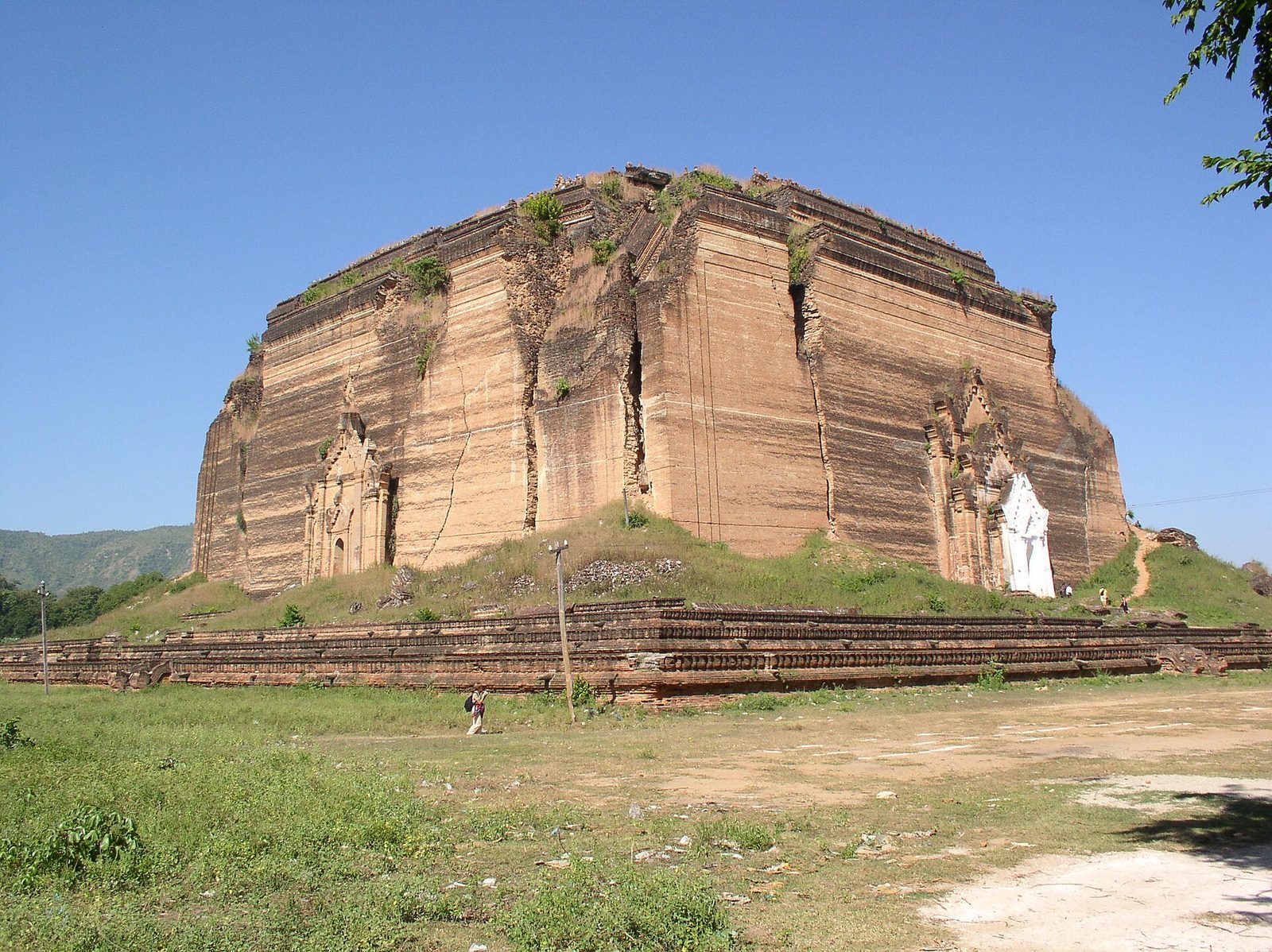 A colossal unfinished brick pagoda base with cracks from an earthquake.