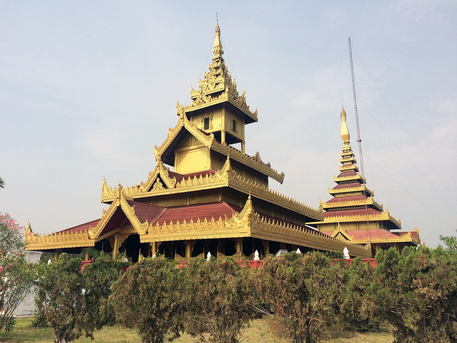 A gilded tiered-roof palace building among trees.