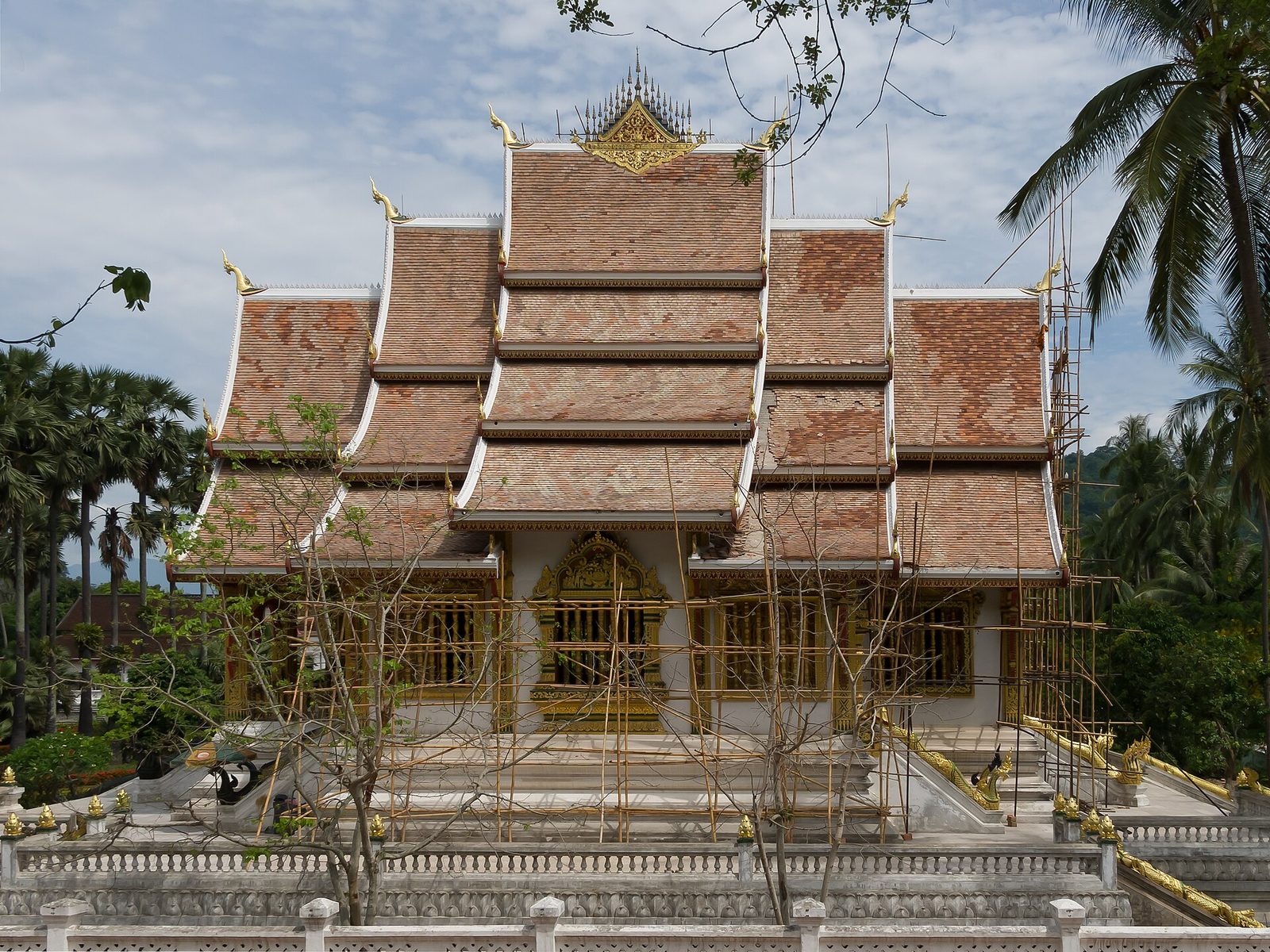 A gilded temple with tiered roofs on a raised platform.
