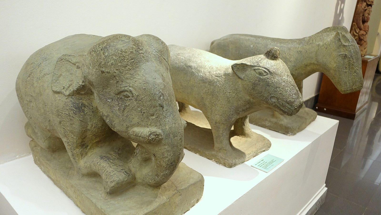 Stone figures of an elephant, a rhinoceros and a horse in a museum.