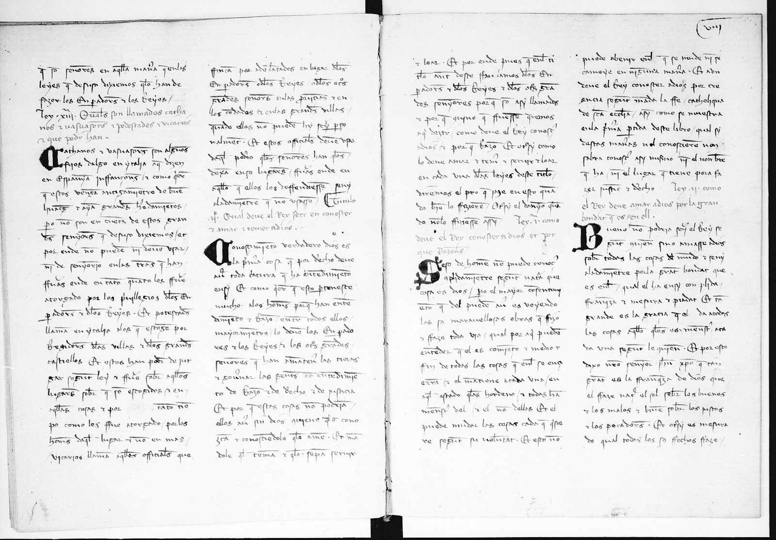 An open manuscript spread of two columns per page in a Gothic hand, with large decorated initials.