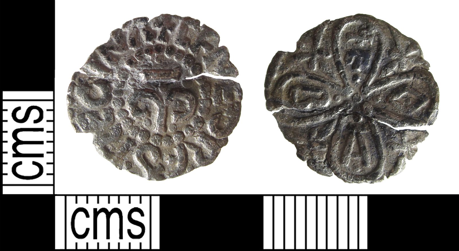 Both faces of a worn silver penny beside a centimetre scale.