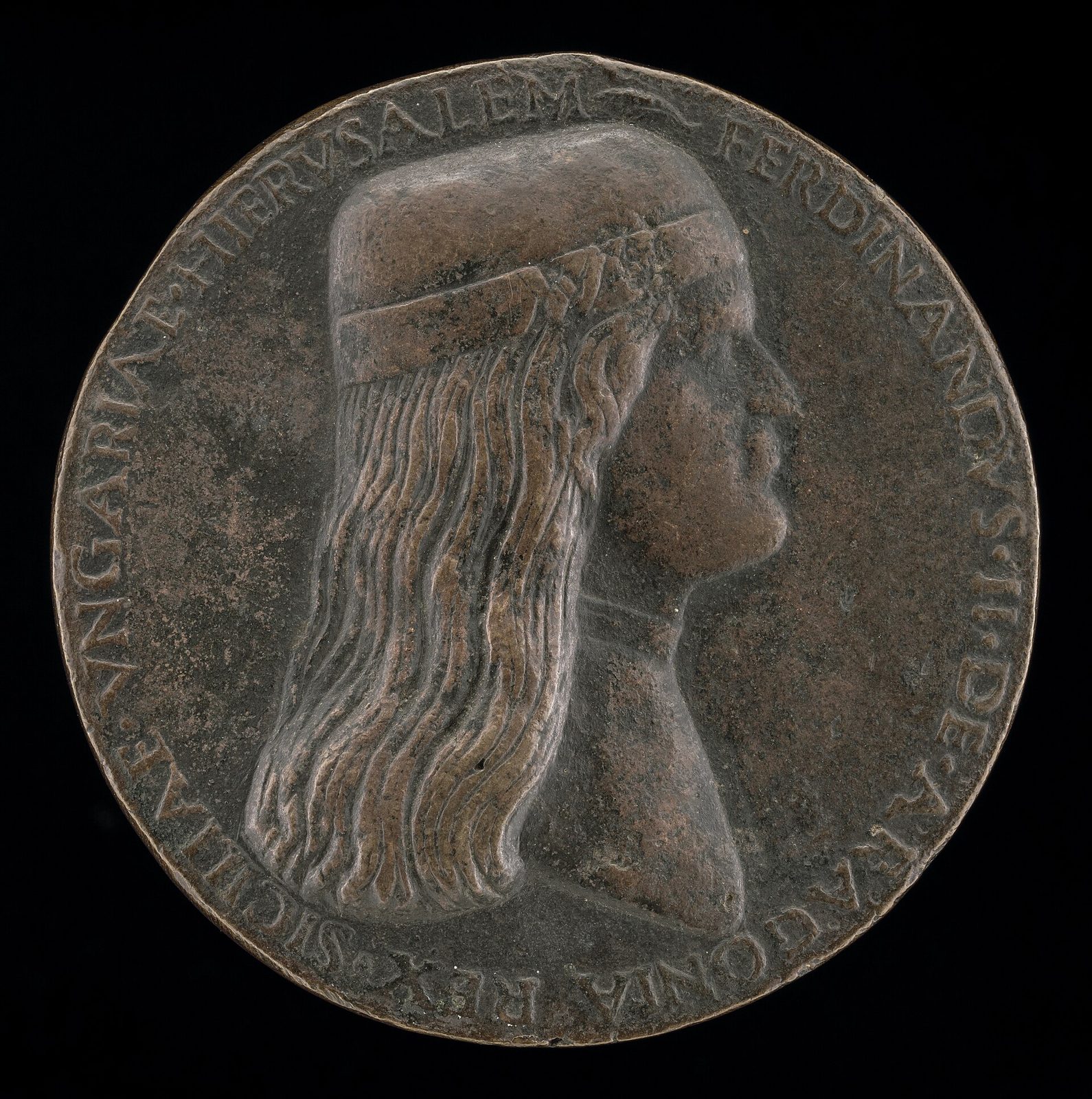 A cast bronze medal: a young man in profile with long hair falling to his shoulders under a plain fillet, ringed by a raised Latin legend.