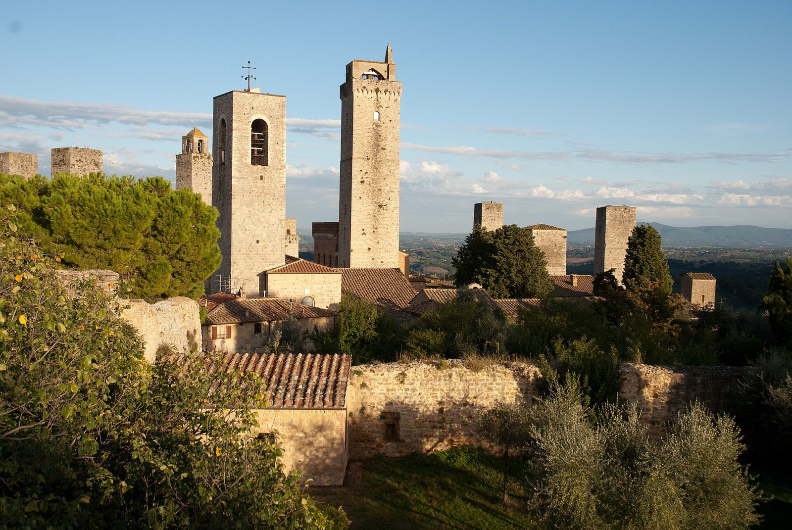 A hilltop town of close-packed stone houses from which more than a dozen tall square towers of different heights rise above the roofs.