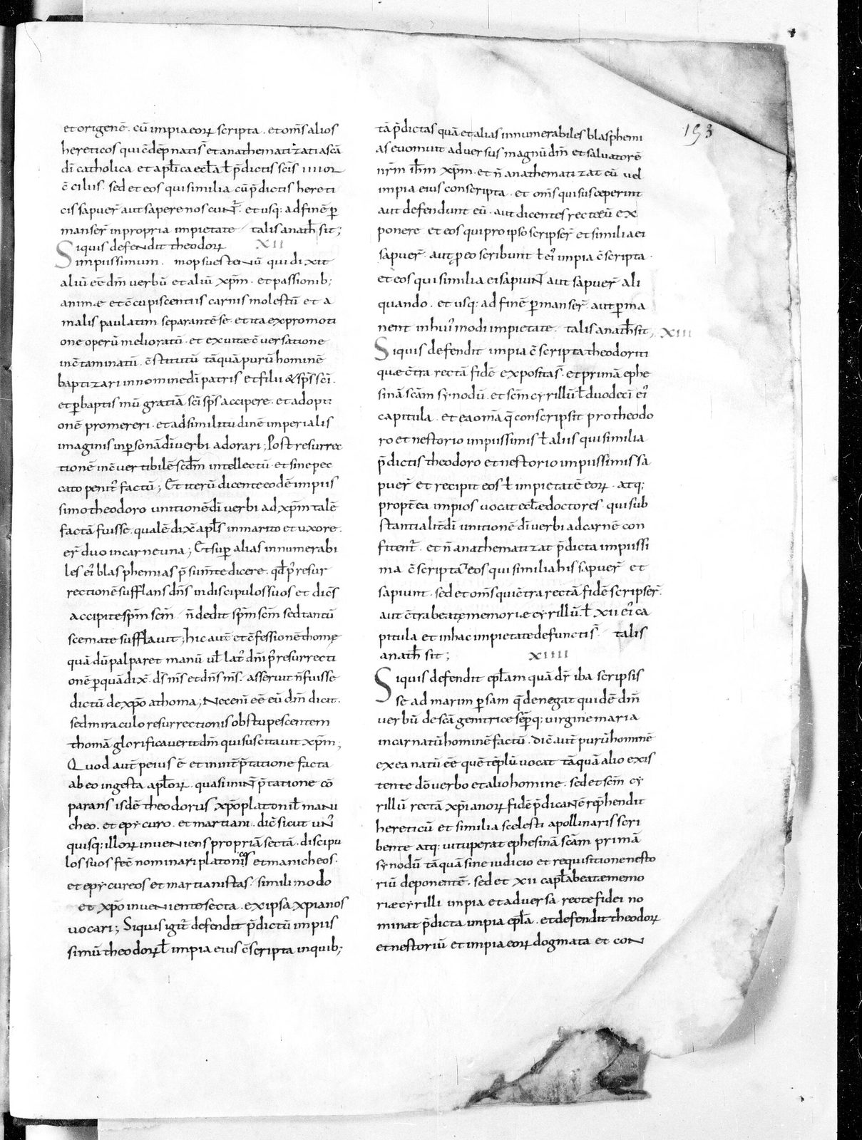 A page of dense early medieval Latin in a single column, the parchment stained and cockled along one edge, with a few words marked in a darker ink.