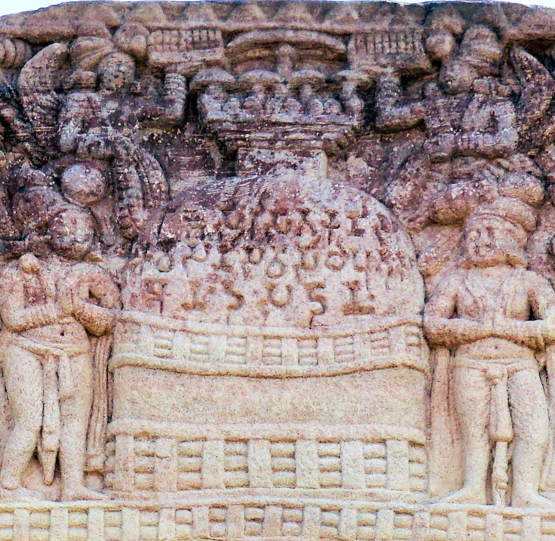 A carved sandstone panel showing a stupa between figures, with lines of Brahmi cut across its dome.