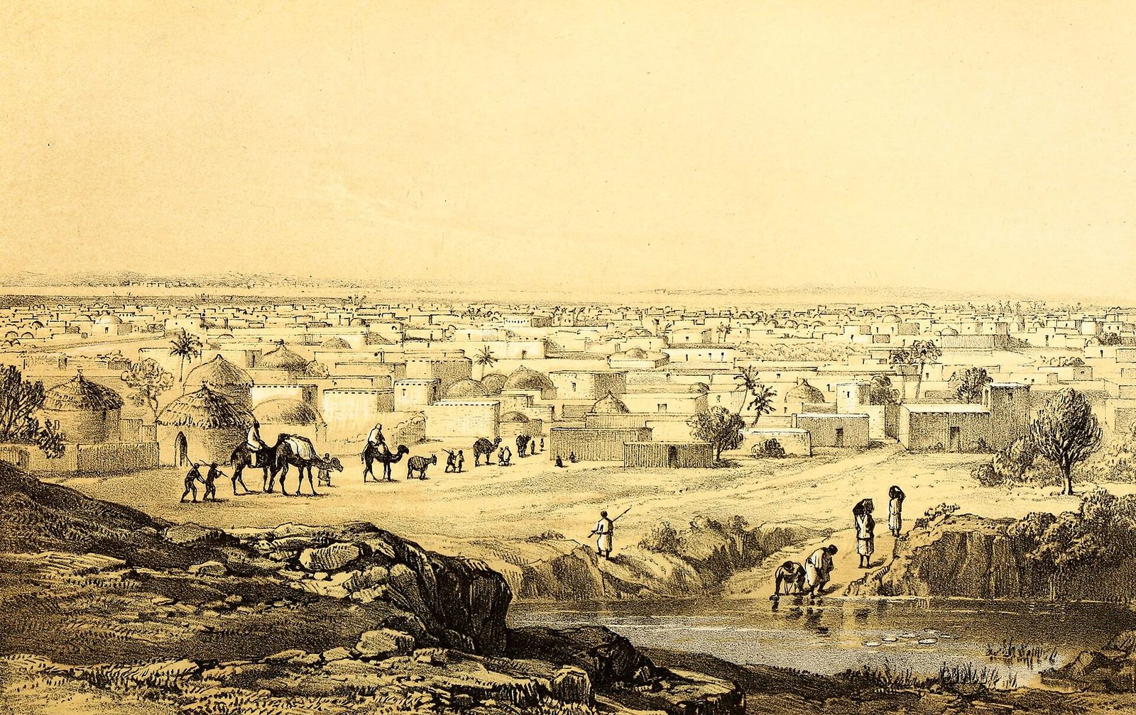 A tinted lithograph of a wide town of flat-roofed houses and trees on a plain, camels and people by a pool in front.
