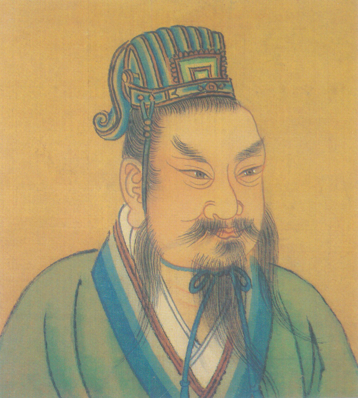 A painted bust of a moustached man in a blue and green cap and robe.