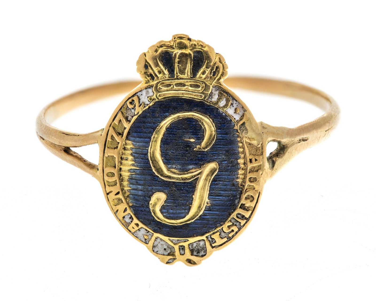 A gold ring with a crowned oval bezel of blue enamel bearing a gold letter G.