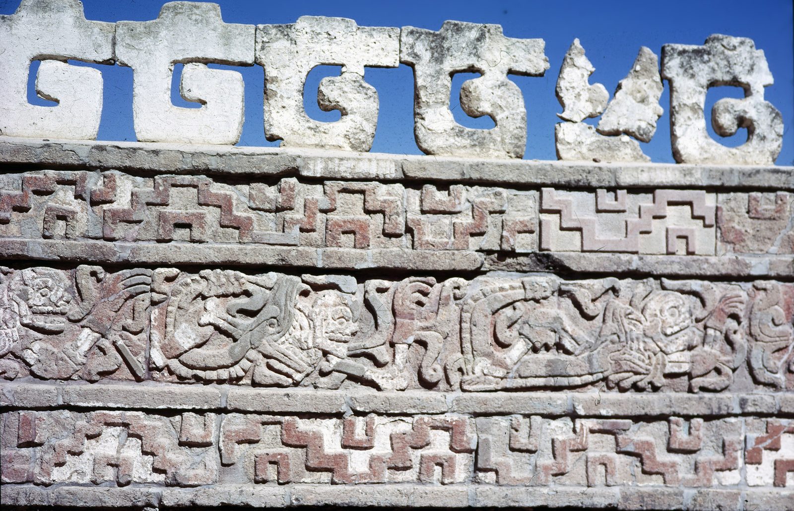 A carved stone frieze with stepped crenellations above bands of relief.