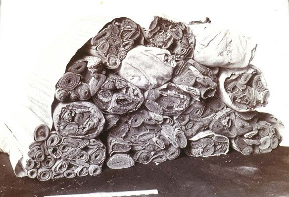 A black-and-white photograph of a heap of tied bundles of manuscript scrolls.